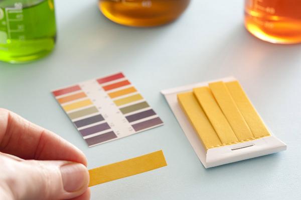 Free Stock image of Chemist holding a pH strip of litmus ...